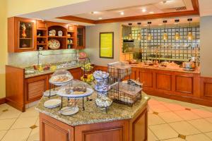 a large kitchen with a buffet with dishes on a counter at Hilton Garden Inn Joplin in Joplin