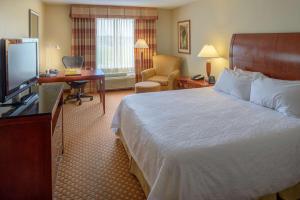 a hotel room with a bed and a television at Hilton Garden Inn Joplin in Joplin