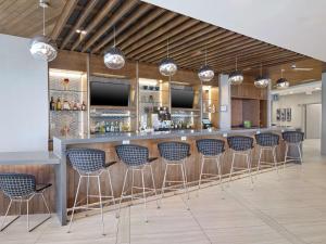 - un bar avec tabourets bleus dans une pièce dans l'établissement DoubleTree by Hilton Edmonton Downtown, à Edmonton