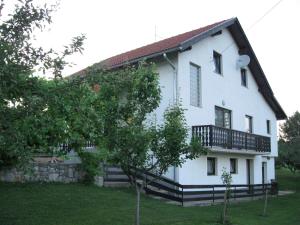 a white house with a balcony on the side of it at Apartments Dale in Plitvička Jezera
