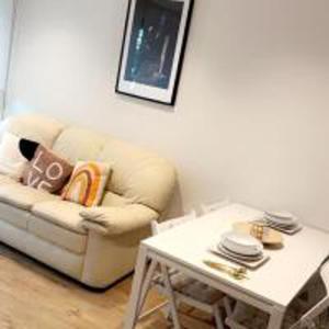 a living room with a couch and a table at Tee SweetLux Apartment In Canning Town in London