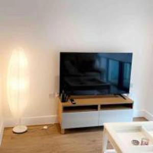 a living room with a large flat screen tv at Tee SweetLux Apartment In Canning Town in London