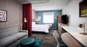 een hotelkamer met een bed en een bank bij Home2 Suites By Hilton Brantford in Brantford