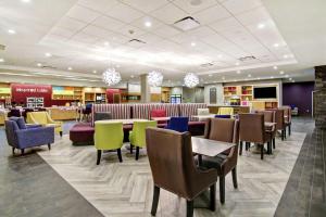 eine Lobby mit Tischen und Stühlen und ein Restaurant in der Unterkunft Home2 Suites By Hilton Edmonton South in Edmonton