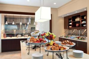 a table with plates of food on it in a kitchen at Hilton Garden Inn Edmonton International Airport in Leduc