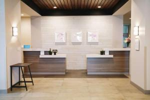 um consultório dentário com dois lavatórios e uma mesa em Hilton Garden Inn Fredericton em Fredericton