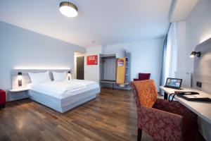 a bedroom with a bed and a desk and a chair at Eden Hotel Früh am Dom in Cologne