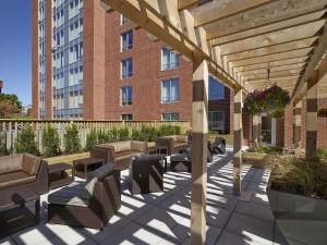 a wooden pergola with chairs and tables in front of a building at Hampton Inn by Hilton Halifax Downtown in Halifax