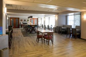Hampton Inn Ellensburg في إلينسبورغ: منطقة لتناول الطعام مع طاولات وكراسي في غرفة