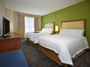 a hotel room with two beds and a flat screen tv at Hampton Inn by Hilton Halifax Downtown in Halifax