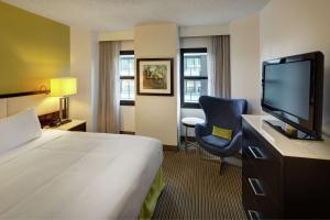 um quarto de hotel com uma cama e uma televisão de ecrã plano em The Hollis Halifax - a DoubleTree Suites by Hilton em Halifax