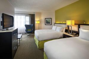 a hotel room with two beds and a flat screen tv at The Hollis Halifax - a DoubleTree Suites by Hilton in Halifax
