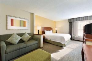 a hotel room with a bed and a couch at Hampton Inn Youngstown/Boardman in Poland
