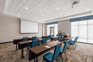 a conference room with tables and chairs and a screen at Hampton Inn & Suites Kelowna, British Columbia, Canada in Kelowna