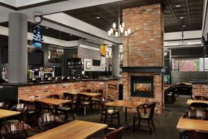 a restaurant with tables and chairs and a fireplace at Hampton Inn & Suites by Hilton Langley-Surrey in Surrey
