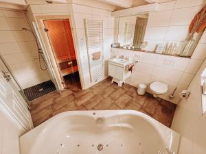 Baño blanco con bañera y lavamanos en ViLLA WASSERSTADT en Nordhorn