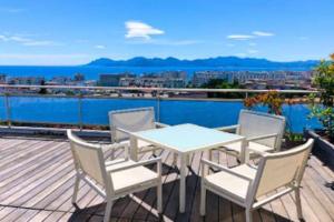 a white table and chairs on a deck with a view at Penthouse Cannes 100m2 avec 2 suites et terrasse 80m2 in Cannes