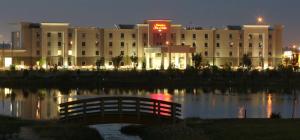 a large building with a bridge over a body of water at Hampton Inn & Suites Red Deer in Red Deer