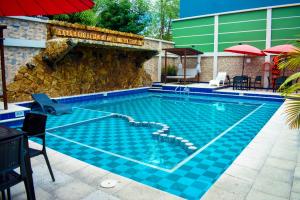a swimming pool with blue tiles on the side of a building at Hotel Punta Arena Spa Boutique in Arauca