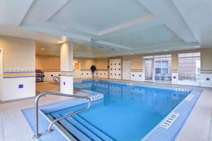 a large swimming pool with blue water in a building at Homewood Suites by Hilton Sudbury in Sudbury