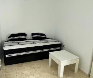 1 cama con almohadas blancas y negras y taburete en Apartamento SeaView en Sitio de Calahonda