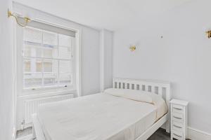 Habitación blanca con cama y ventana en Charming 4 bed town house with roof terrace en Londres