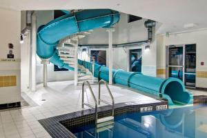 une piscine avec un toboggan bleu dans un bâtiment dans l'établissement Hampton Inn & Suites Saint John, à Saint-Jean