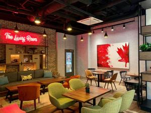 a restaurant with tables and chairs and a couch at Canvas Moncton, Tapestry Collection By Hilton in Moncton
