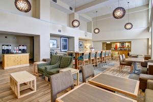 a restaurant with tables and chairs and a bar at Hampton Inn & Suites Saint John in Saint John