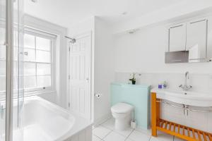 een badkamer met een bad, een toilet en een wastafel bij Charming 4 bed town house with roof terrace in Londen