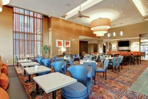 a dining room with tables and blue chairs at Homewood Suites by Hilton Toronto-Ajax in Ajax