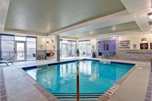 a large swimming pool with blue water in a building at Homewood Suites by Hilton Toronto-Ajax in Ajax