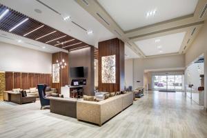 eine Lobby mit Sofas und Stühlen sowie einem TV in der Unterkunft Doubletree by Hilton Toronto Airport, ON in Toronto