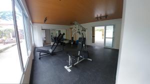 uma academia com esteiras e equipamentos de ginástica em uma sala em Apartamento Jardim das Palmeiras II - Ubatuba em Ubatuba