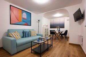 un soggiorno con divano blu e tavolo di Diomira Apartment a Taormina