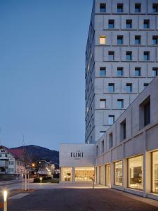 a building with a trump sign on the side of it at Das Flint in Dornbirn