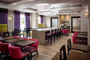 a restaurant with tables and chairs and a bar at Hampton Inn by Hilton Timmins in Timmins