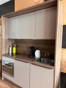 una cocina con armarios blancos y fregadero en Amazing Studio S3, City Centre Dordrecht en Dordrecht