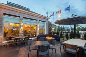 eine Terrasse mit Tischen und Stühlen und ein Restaurant in der Unterkunft Hilton Garden Inn Toronto-Oakville in Oakville