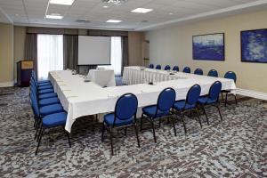 a large conference room with a long table and blue chairs at Hilton Garden Inn Toronto-Oakville in Oakville +20 photos