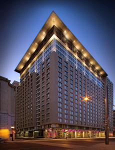 a large building with lights on top of it at Embassy Suites by Hilton - Montreal in Montreal