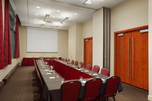 uma sala de conferências com uma mesa longa e cadeiras vermelhas em Embassy Suites by Hilton - Montreal em Montreal