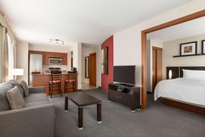a hotel room with a bed and a living room at Embassy Suites by Hilton - Montreal in Montréal