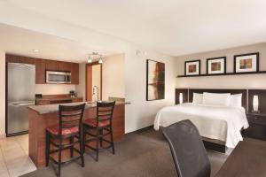 um quarto de hotel com uma cama e uma cozinha em Embassy Suites by Hilton - Montreal em Montreal