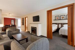 a hotel room with a bed and a living room at Embassy Suites by Hilton - Montreal in Montréal