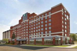 un gran edificio de ladrillo rojo con un reloj. en Embassy Suites By Hilton Montreal Airport en Pointe-Claire