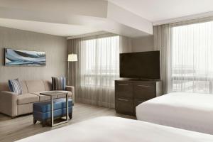 a hotel room with a bed and a television at Embassy Suites By Hilton Montreal Airport in Pointe-Claire