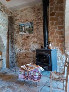 a living room with a stone wall and a stove at The House of Pericles in Silikou