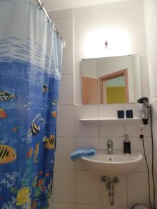a bathroom with a sink and a shower curtain at Gasthof zum Hirsch in Neukirch