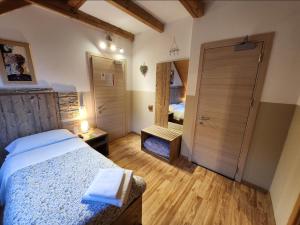 a bedroom with a bed and a door with a mirror at Hotel Tarvisio in Tarvisio